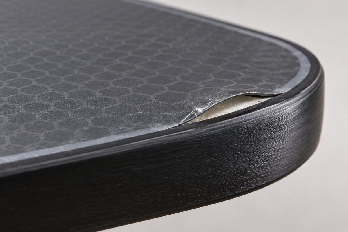 close up of pickleball paddle edge showing delamination, a sign how long does a pickleball paddle last is running out