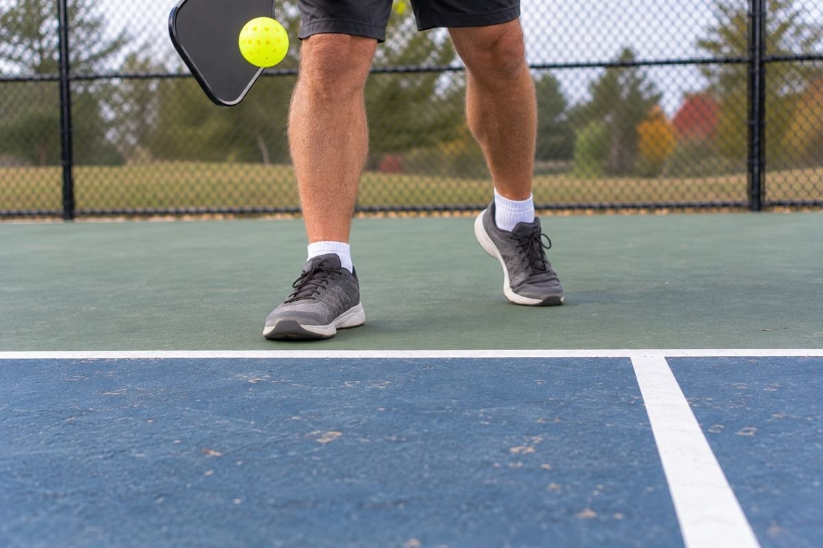 Server's feet behind the baseline at contact, as the pickleball serving rules require